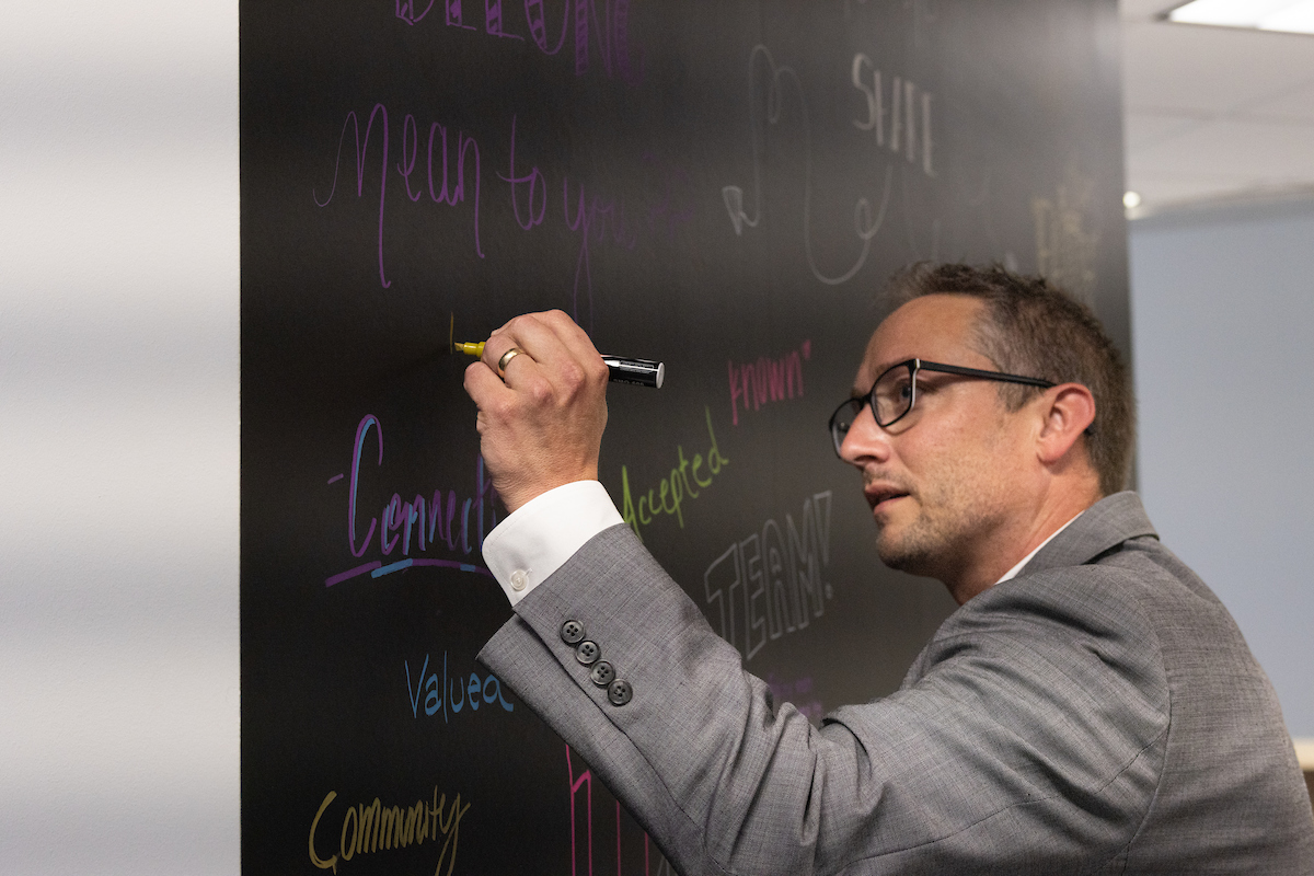 A faculty member contributing to the community chalk board